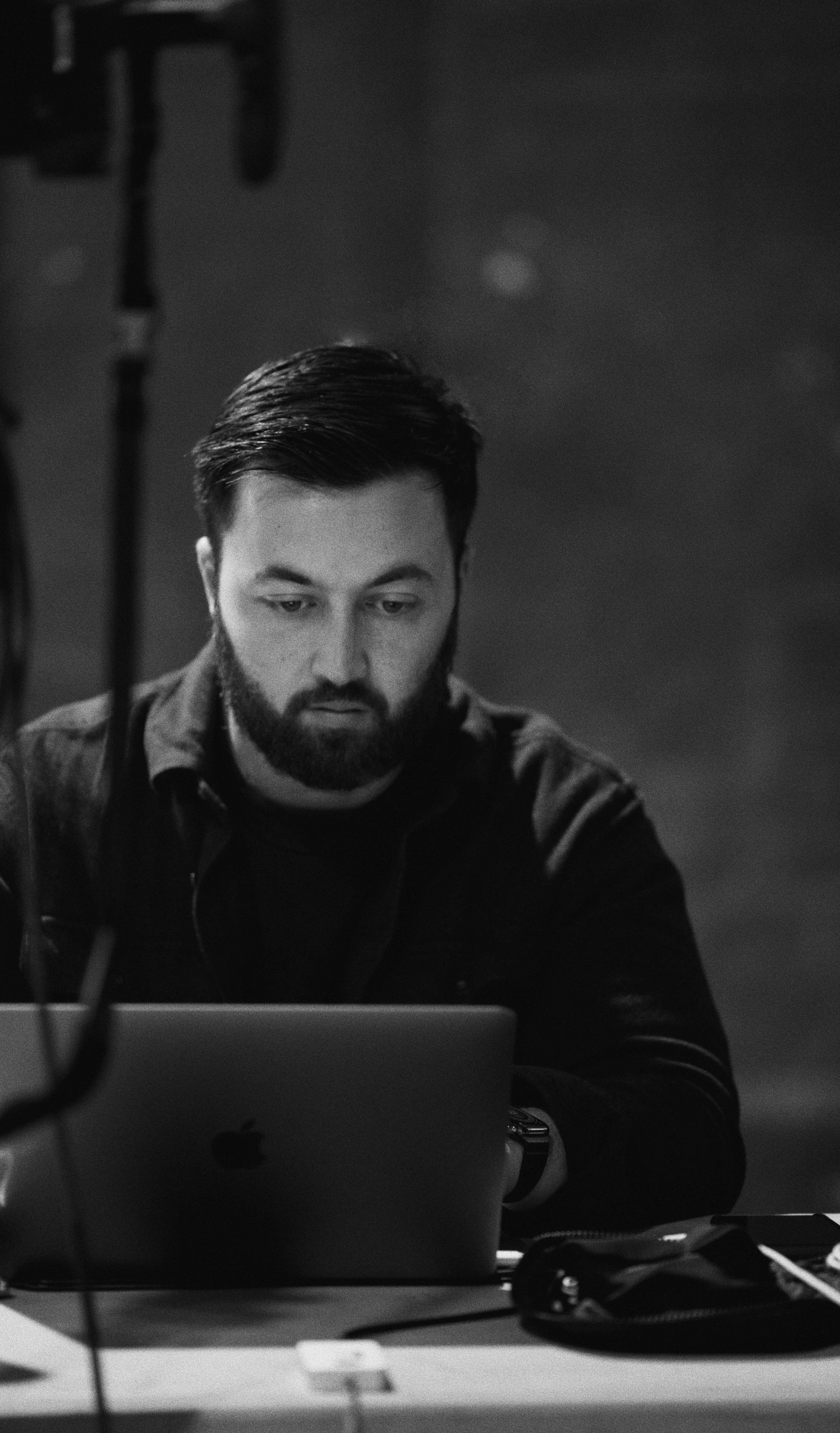 Steven Garrett at a laptop on set, a stand and cables in the foreground.