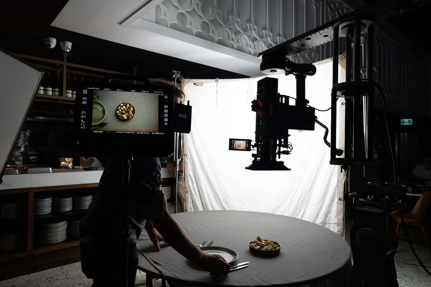 A camera and monitor aimed at a plated dish on a round table, the still used for Content Producer.